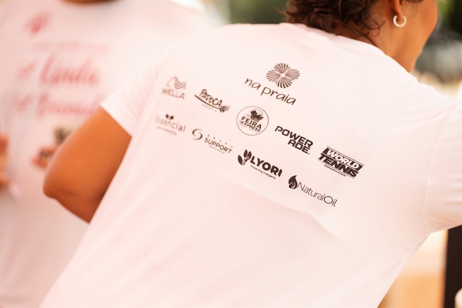 Costas da camiseta oficial do evento com as logos das marcas parceiras